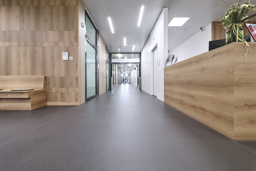 Blick durch den Spital-Flur zwischen Empfang und Wartebereich. Für die Verkehrsflächen wurde der Bodenbelag noracare seneo gewählt.